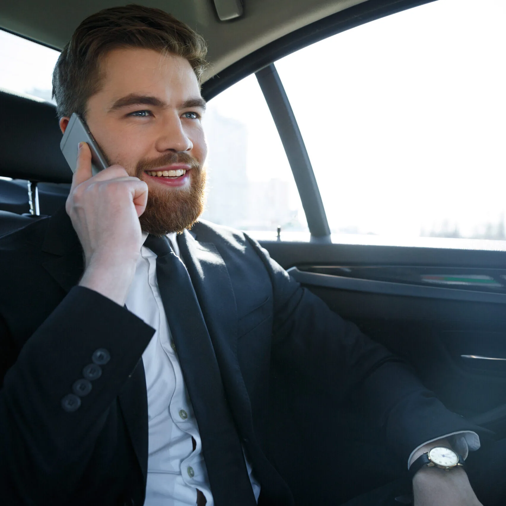 Businessmen,Talking,On,Phone,On,the,Back,Seat,Of,The,Car.